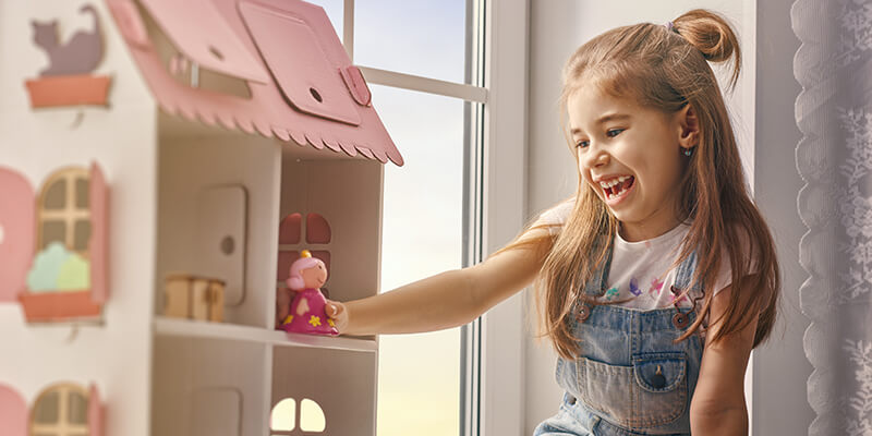 girl playing with dolls house