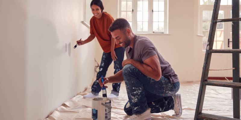 Couple laughing painting room