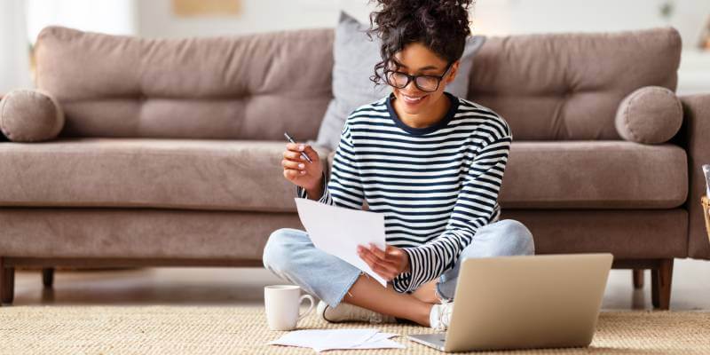 Woman sitting on the floor doing paperwork